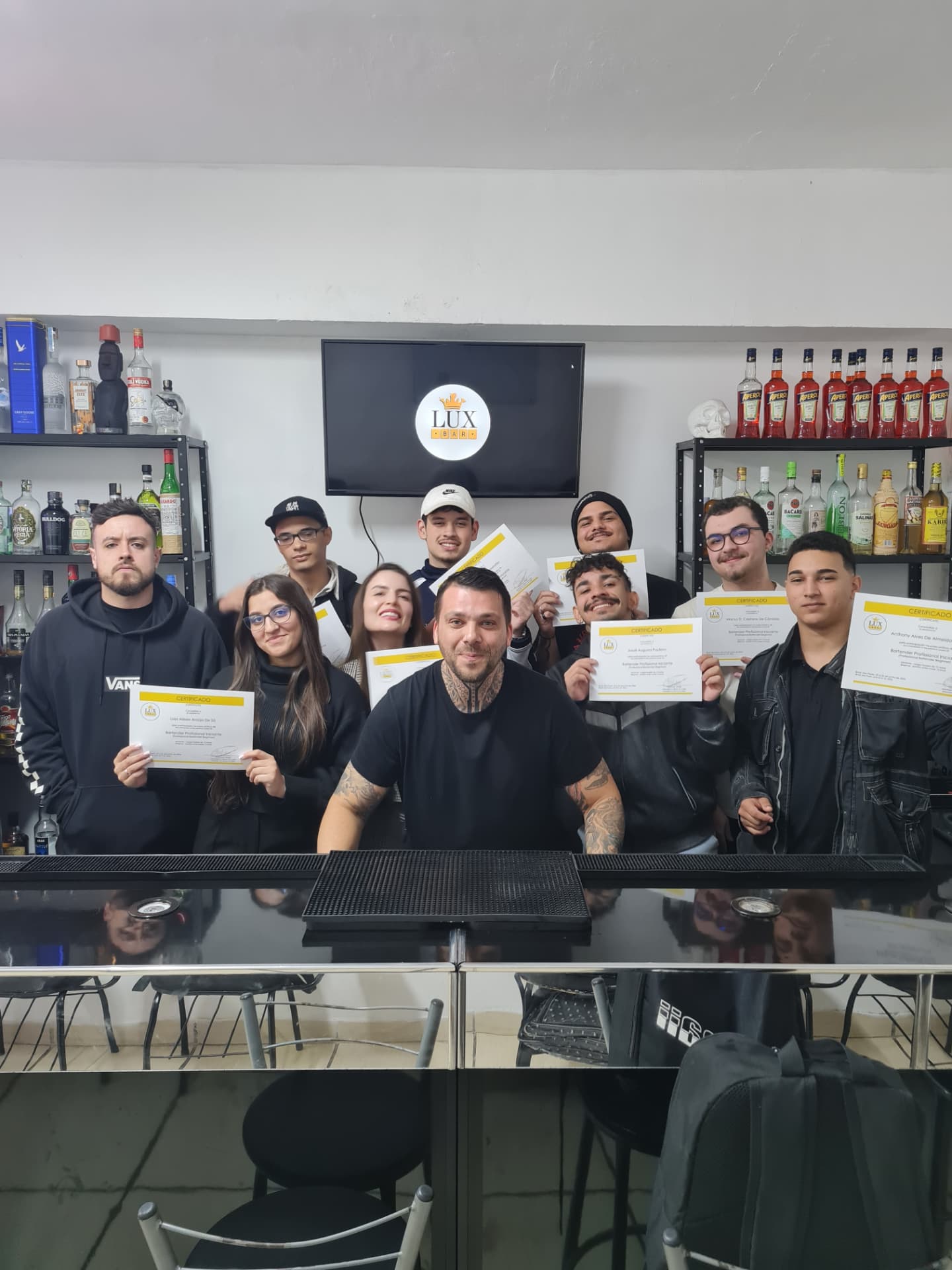 Turma de bartender da LuxBar exibindo os certificados no bar-escola