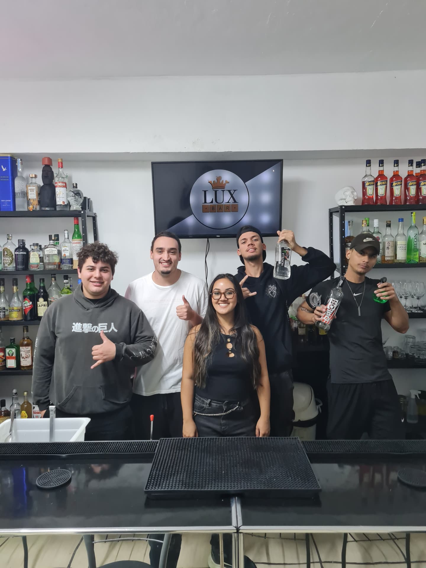Alunos em aula prática atrás da bancada de bar da LuxBar