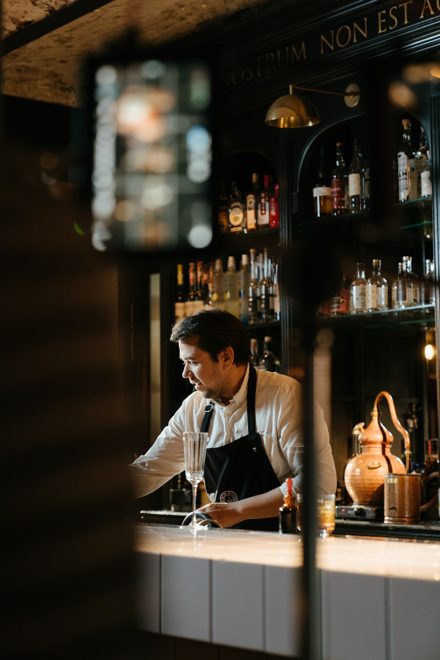 Bartender preparando um coquetel em um bar, demonstrando técnica de mixologia