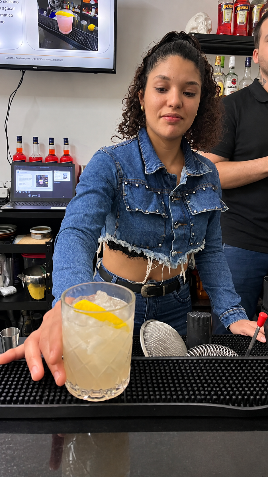 Aluna apresentando o drink preparado em aula